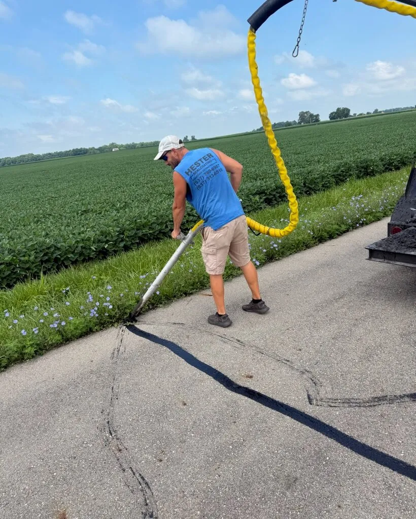 Hester crew member applying hot rubberized crack filler